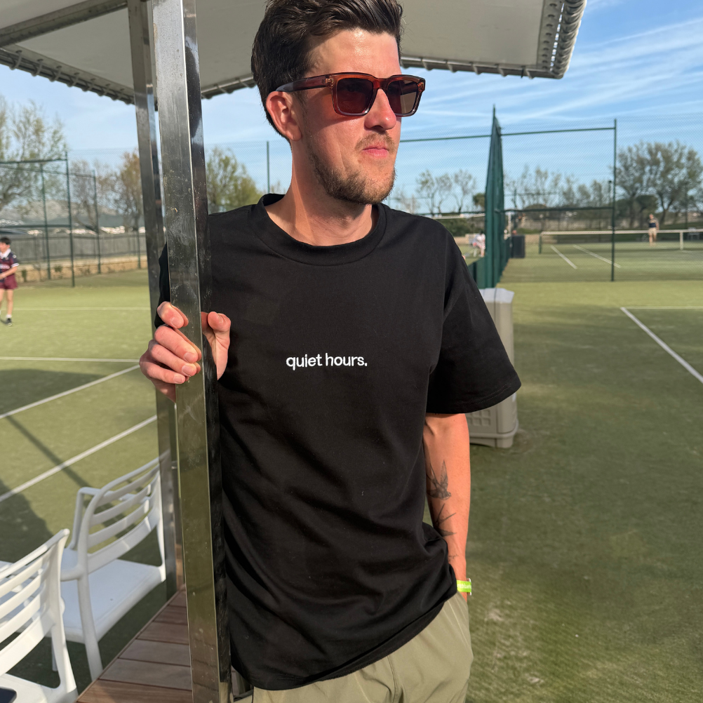 black t-shirt with 'quiet hours' on a tennis court